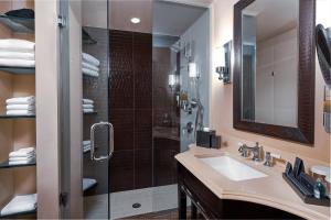 
a bathroom with a sink, mirror, and a toilet at National Hotel, An Adult Only Oceanfront Resort in Miami Beach
