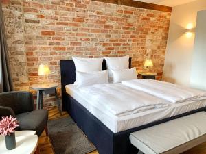 ein Schlafzimmer mit einem großen Bett mit Ziegelwand in der Unterkunft Wyndberg in Lüneburg