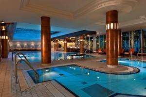 a swimming pool in a hotel with columns at Radisson Blu Park Hotel & Conference Centre in Dresden