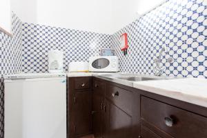 a kitchen with a sink and a microwave at Apartamentos Turisticos Marsol in Lagos