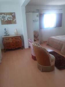 a bedroom with a bed and a chair and a mirror at Cacho D´ouro in Santa Marta de Penaguião
