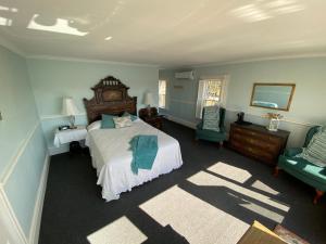 a bedroom with a large bed and two chairs at The Tuna Blue Inn in Hubbards