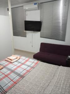 1 dormitorio con cama, sofá y canasta de baloncesto en Monoambiente nuevo en La Banda