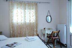 a room with a white table and a white refrigerator at Apartments Avra in Lefkada