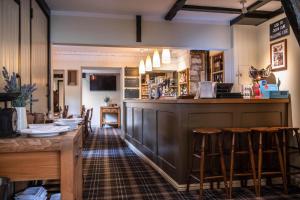 un bar con taburetes de madera en un restaurante en Wheelwrights Arms Country Inn & Pub, en Bath