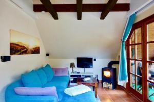 a living room with a blue couch and a tv at Haus am Wald Klingberg in Klingberg
