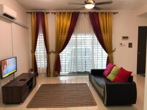 a living room with a couch and a tv at Hasnifana Homestay Seri Iskandar in Seri Iskandar