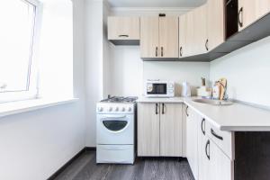 a kitchen with a white stove top oven next to a sink at 2к квартира на Республике напротив гостиницы ВОСТОК in Tyumen