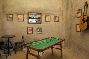 a room with a pool table and a guitar at bnb+Atami Resort in Atami