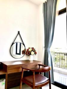a desk with a mirror and a chair next to a window at Hotel Hạnh Phúc in Ha Long