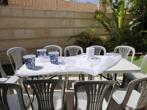 a white table and chairs with cups on it at EILAT GOLF RESIDENCE Apartment A 1 in Eilat