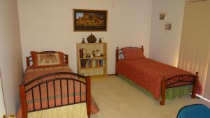 a bedroom with two beds and a book shelf at Effie Court in Springvale South