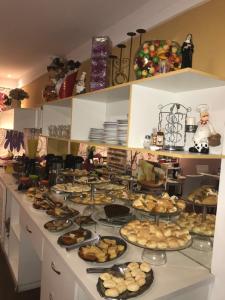 a counter with many plates of food on it at Aton Plaza Hotel in Goiânia