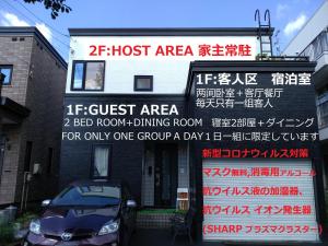 ein Gebäude mit einem Schild, das nur das Zimmer im Gästebereich liest in der Unterkunft At Home N23 in Sapporo