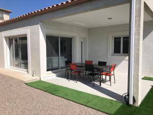 una casa con patio con mesa y sillas en Villa les agrumes, en Narbona