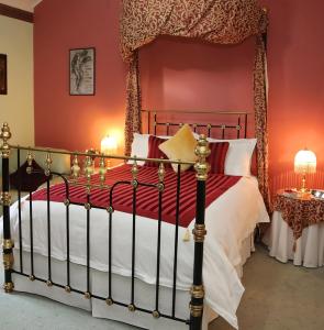 ein Schlafzimmer mit einem Himmelbett mit roten Wänden in der Unterkunft Forgandenny House B&B in Mudgee
