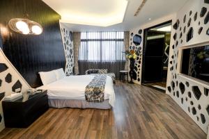 a hotel room with a bed and a tv at Blossom Motel in Puxin +25 photos