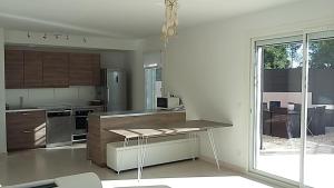 a kitchen with stainless steel appliances and a large window at Les Bastides du Haut Para in Bormes-les-Mimosas