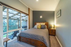 una camera da letto con un letto e una grande finestra di Platypus Waters B&B a Smithton