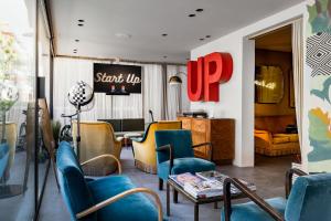 een lobby met blauwe stoelen en een tafel en een wachtkamer bij Up Hotel in Rimini