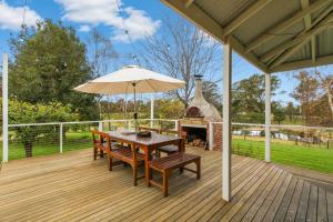 a wooden deck with a table and an umbrella at Country House Retreat in Nungurner