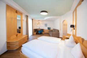 a bedroom with two beds and a living room at Garni Luziafeld Hof in Appiano sulla Strada del Vino