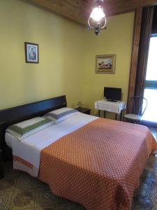 a bedroom with a bed and a desk with a laptop at Antico Palazzo in Giardini Naxos