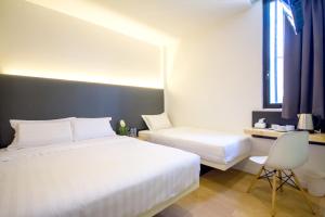a hotel room with two beds and a desk at Mode Inn Icon City in Bukit Mertajam