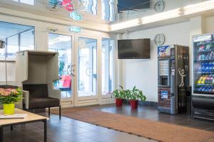 a waiting room with a refrigerator and a tv on the wall at Academic Hostel in Tallinn