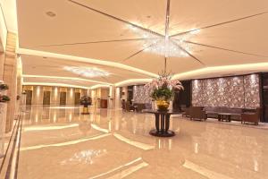 eine große Lobby mit einem Kronleuchter sowie Tischen und Stühlen in der Unterkunft The Splendor Hotel Taichung in Taichung