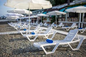 a row of chairs and umbrellas on a beach at Zhemchuzhina Grand Hotel in Sochi