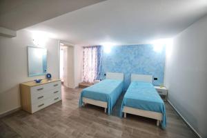 sypialnia z 2 łóżkami, komodą i lustrem w obiekcie CASA VACANZA NELLE MALDIVE DEL SALENTO w mieście Torre Vado