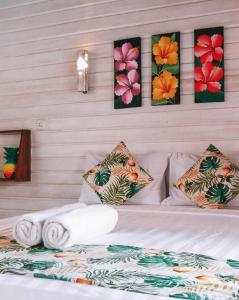 a bedroom with a bed with towels and paintings on the wall at Voodoo Gili in Gili Trawangan