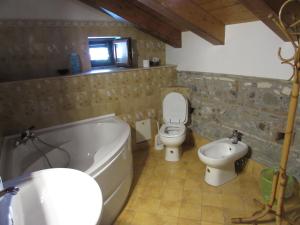a bathroom with a tub and a toilet and a sink at Antico Palazzo in Giardini Naxos