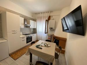 a small kitchen with a table and a television on a wall at Il grottino Gargano home in Rodi Garganico
