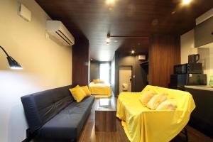 a living room with a couch and a yellow blanket at s-rea TOKYO 101 in Tokyo