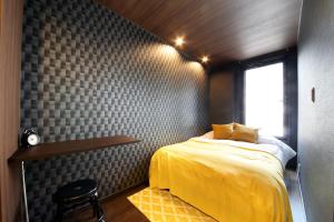 ein Schlafzimmer mit einem gelben Bett und einem Fenster in der Unterkunft s-rea TOKYO 101 in Tokio