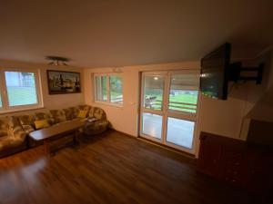 a living room with a couch and a flat screen tv at Chalupa u Bártů in Trojanovice