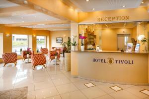 un vestíbulo tipo hotel con recepción y sillas en Hotel Tivoli, en Schlieren