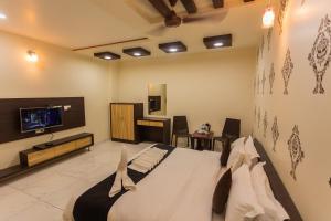 a bedroom with a bed and a flat screen tv at Shri Ram Residency in Jodhpur