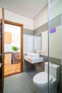 a bathroom with a toilet and a sink at THE NAVIS Hotel & Apartment in Da Nang
