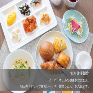 einen Tisch mit Platten aus Lebensmitteln in der Unterkunft Super Hotel Marugame Ekimae in Marugame