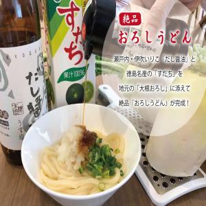 a bowl of noodles with a bottle of wine at Super Hotel Marugame Ekimae in Marugame