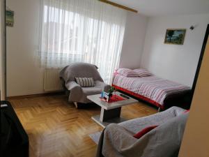 sala de estar con cama y silla en Good Host, en Banja Luka