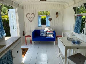 a living room with a blue couch and a table at Little blue house (on the campsite) in Oostvoorne