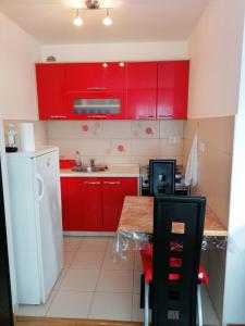 una cocina roja con armarios rojos y fregadero en Good Host, en Banja Luka