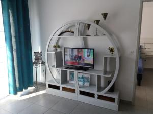 a white shelf with a tv and a mirror at Park Horizon in Sainte-Maxime