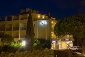 um hotel à noite com uma árvore em frente em Le Petit Prince em Sainte-Maxime