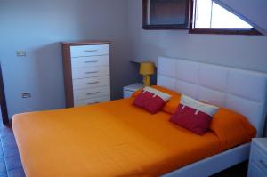 - une chambre avec un lit orange et 2 oreillers rouges dans l'établissement Scerne Holiday Service Attic, à Scerne