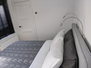 a bedroom with a bed with white pillows and a lamp at Beachtime Suite in Zandvoort